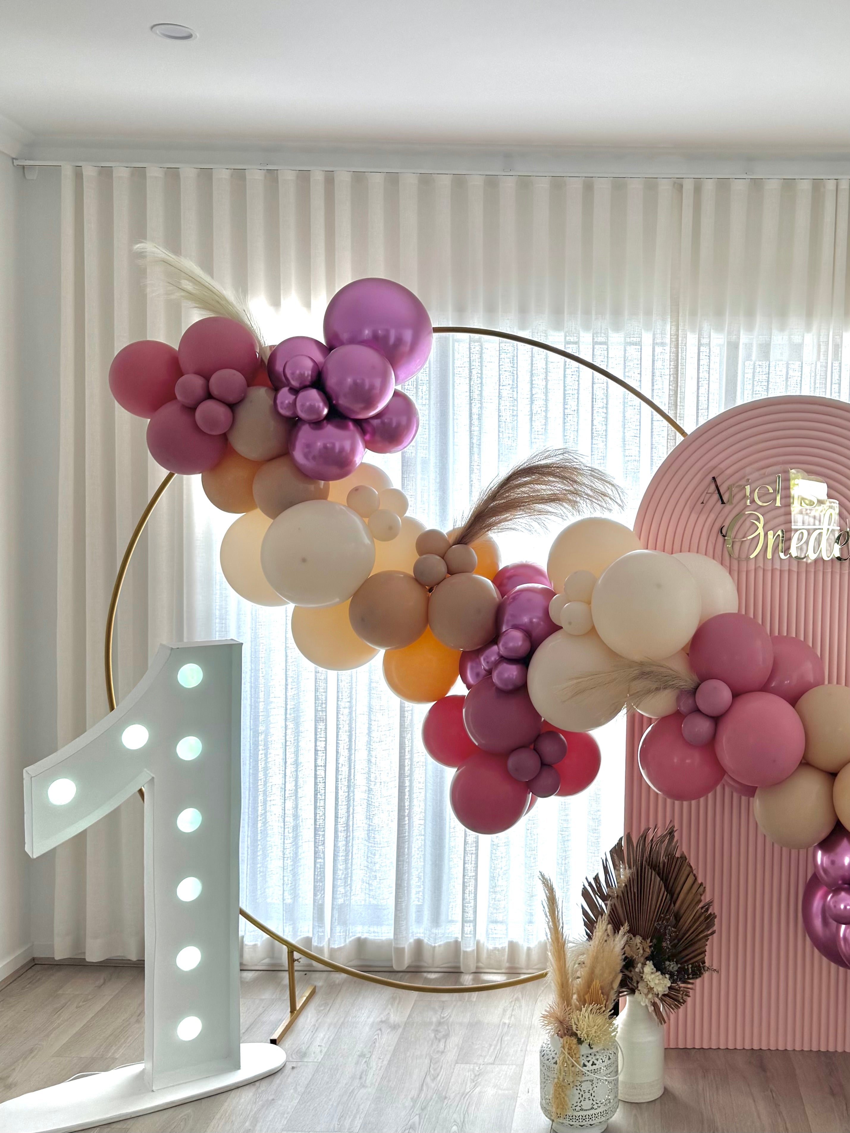 Gold hoop backdrop with balloons garland attached