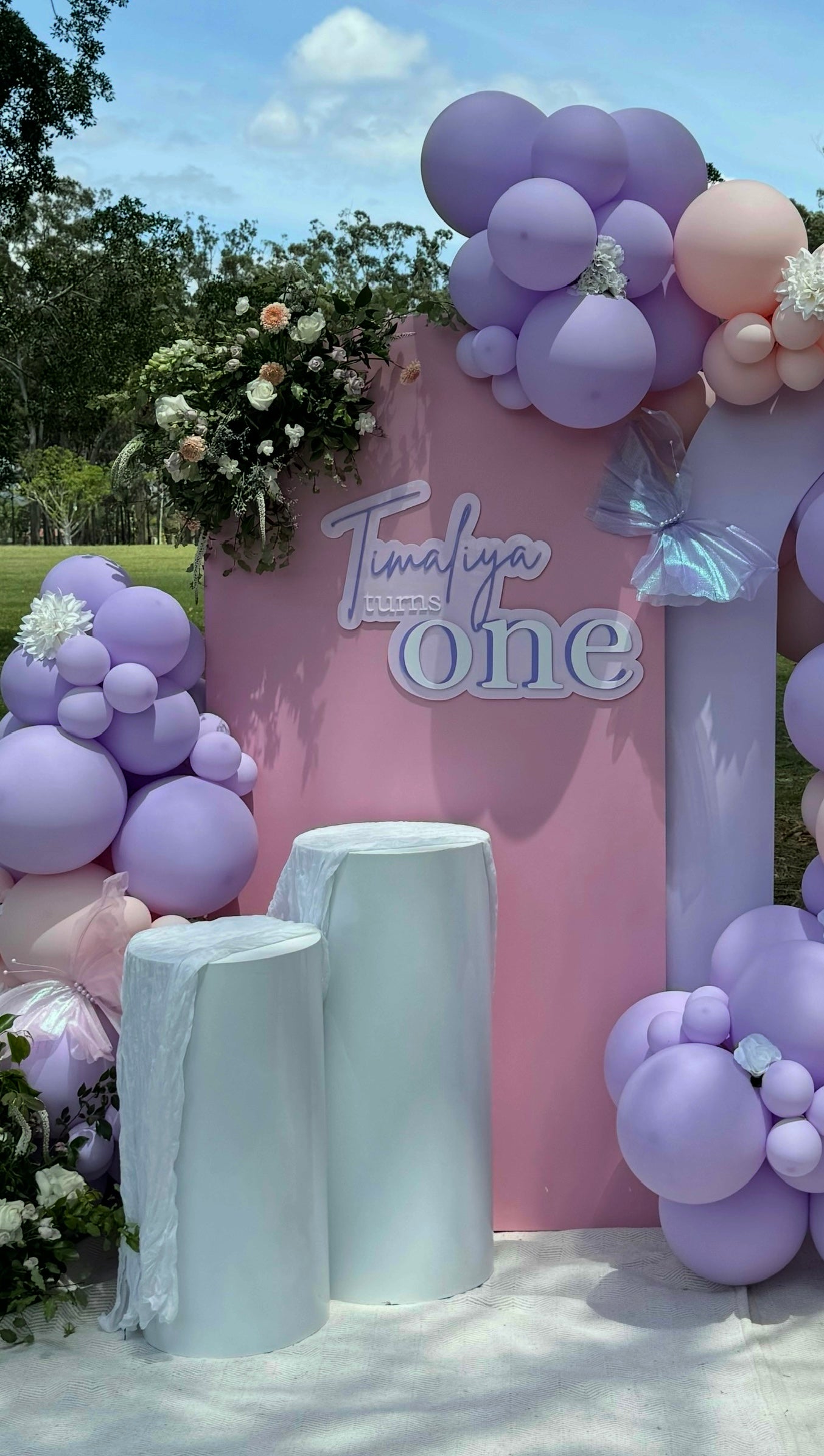 pink arch backdrop with custom balloons and signage attached