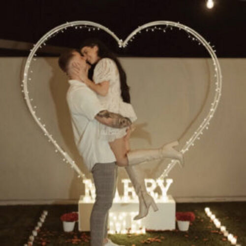 White love heart arbor frame with couple in front