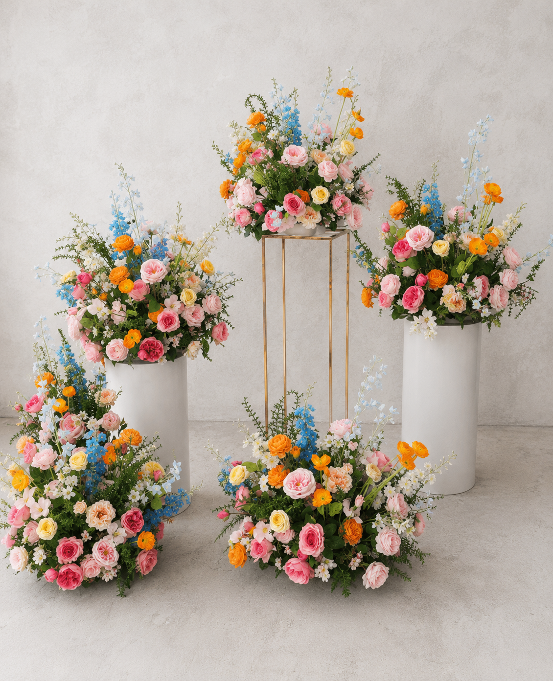 Colourful faux floral arrangements on gold and white plinths