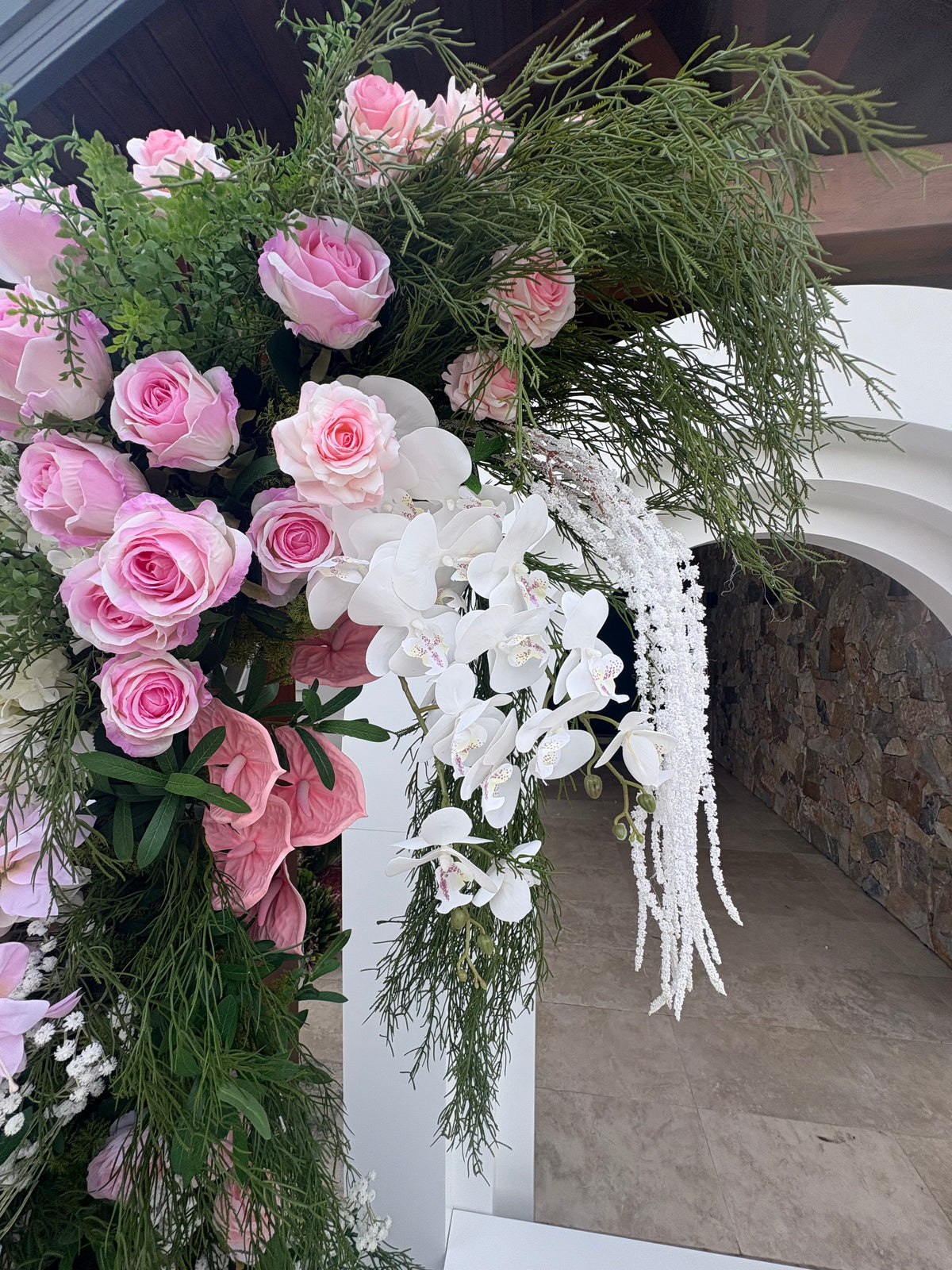 Pink rose and white orchid faux floral pillar at a birthday celebration